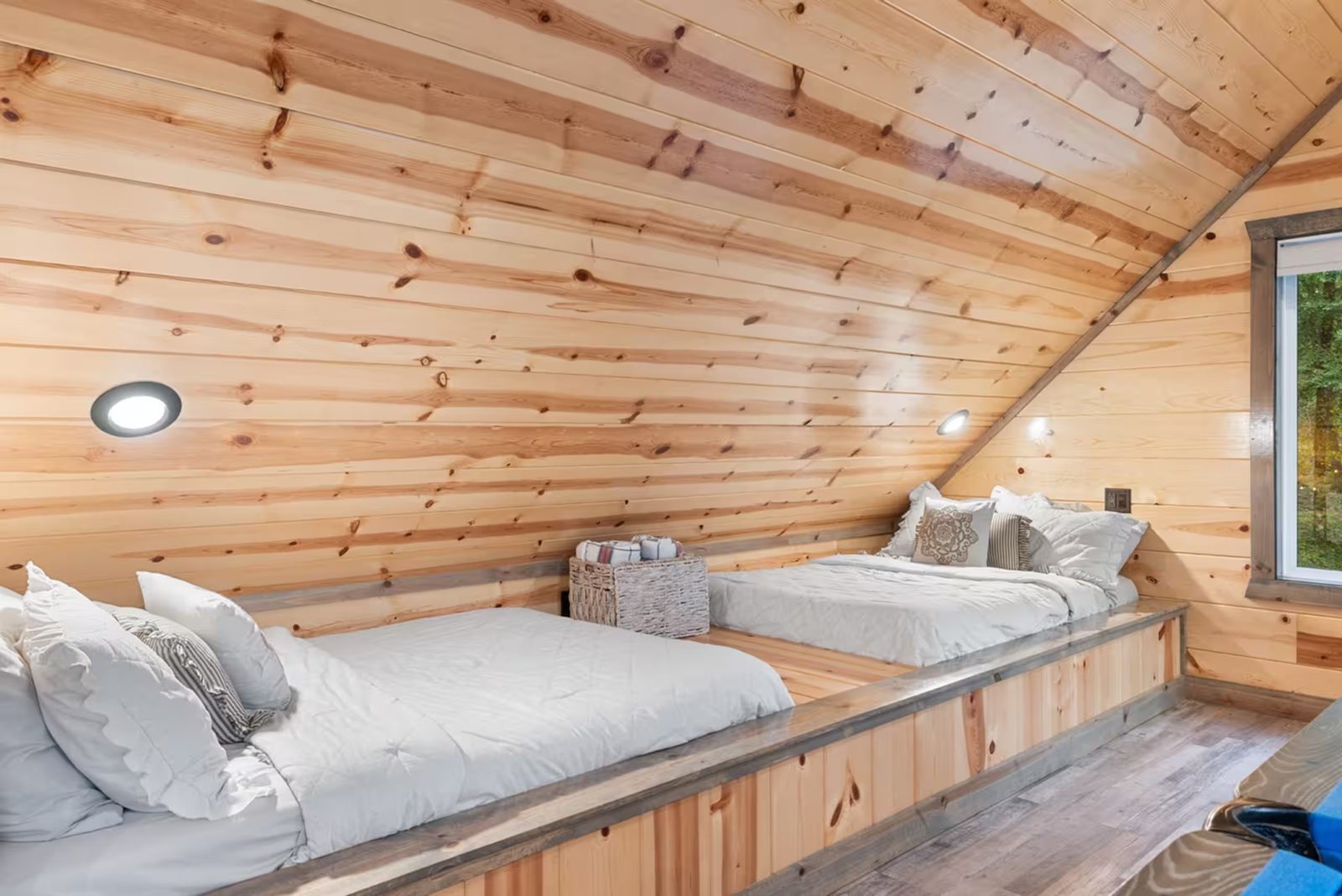Upstairs bedroom under a pine ceiling.
